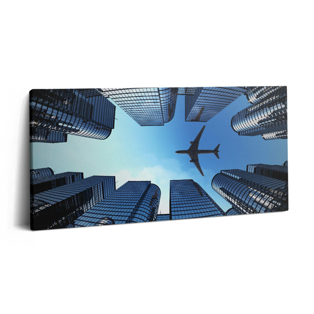 Fotoobraz na plátne 100x50 Lietadlo nad mestskými mrakodrapmi.